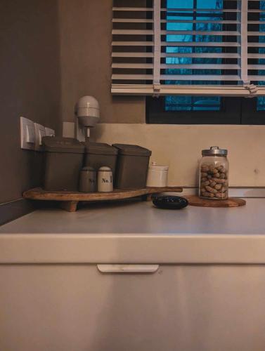 a kitchen counter with a shelf with food on it at Three Dots Boutique Suites in Soúlion
