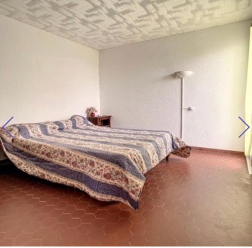 une chambre avec un lit avec une couverture dessus dans l'établissement Accès direct, plage, au Barcarès