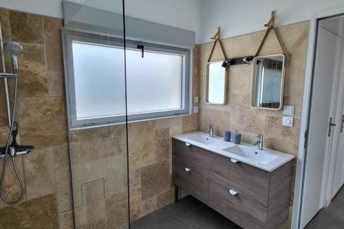 une salle de bain avec un lavabo et une douche en verre dans l'établissement Chambre Chez Sandra et Fabien dans petite maison cœur village, à Maubec