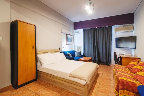 um quarto de hotel com uma cama e um sofá em Alpha 1 em Atenas