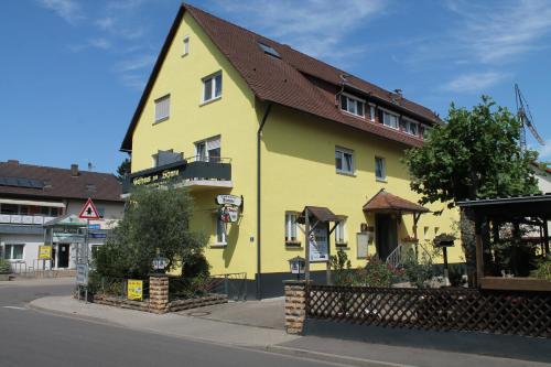 un bâtiment jaune avec un toit brun dans une rue dans l'établissement Gasthaus Zur Sonne, à Fribourg-en-Brisgau