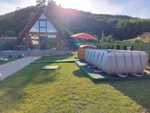 a small house with a boat on the grass at Cabana A-frame Nis in Coţofăneşti