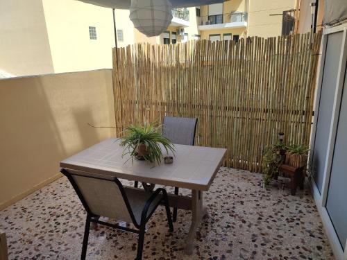 een tafel en stoelen op een balkon met een hek bij margarita home in Kalamata