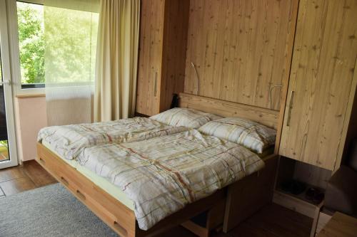 ein Schlafzimmer mit einem Bett in einer Holzwand in der Unterkunft Ferien am Bischofsberg - Edlbach 31 in Windischgarsten