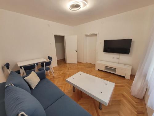 a living room with a blue couch and a table at Happy apartment Strumica 2 in Strumica