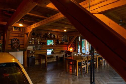 um restaurante com tectos e mesas e cadeiras de madeira em Crossline Lodge em Gheorgheni