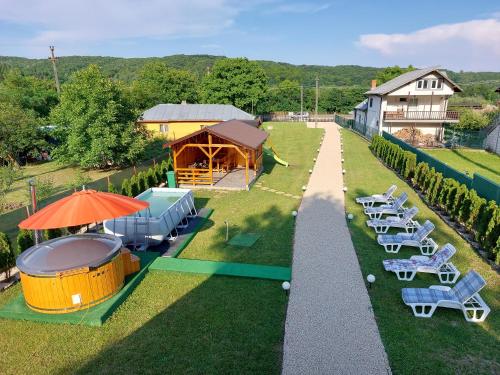 a group of chairs and umbrellas on a lawn at Cabana A-frame Nis in Coţofăneşti