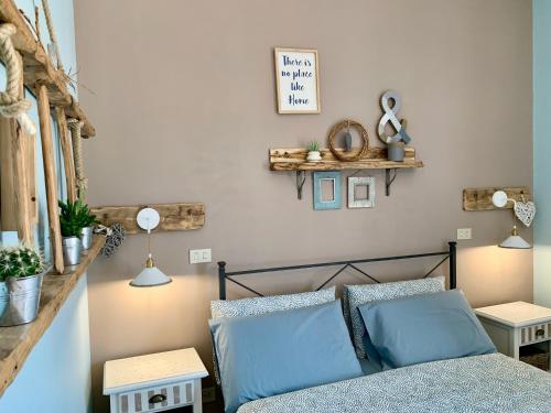 a bedroom with a bed with blue pillows and two tables at Agriturismo La Terrazza su Farfa in Castelnuovo di Farfa
