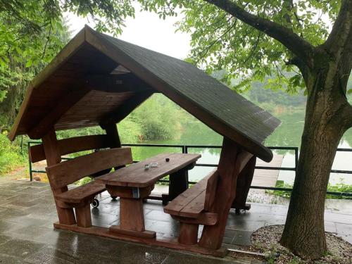 una mesa de picnic de madera con techo sobre un árbol en See Liegenschaft Amstetten-Ost, 