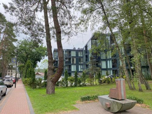 um parque com uma estátua em frente a um edifício em Apartment-Pine Forest Birštonas em Birstonas