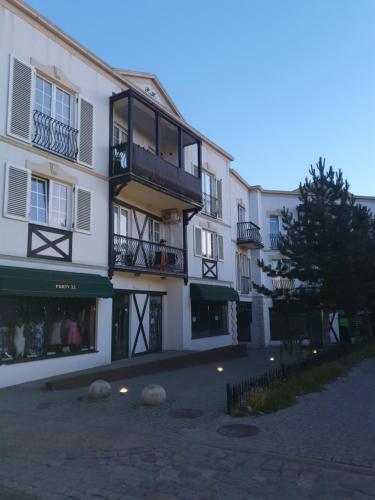 a large white building with a balcony on a street at Apartament City Center JAPAN - no smoking, free bottled water, coffea and tea in Koszalin