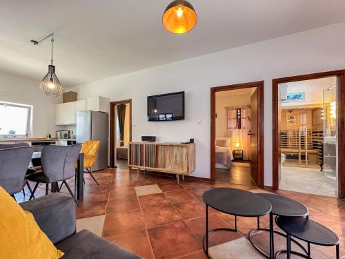 a living room with a table and chairs and a kitchen at MUSTRA House Zadar - Private Pool & Sauna in Zadar