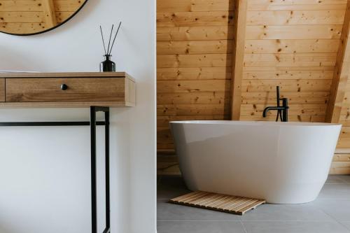 baño con bañera blanca y pared de madera en A Présházikó, en Csákberény