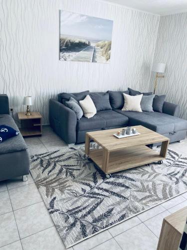 a living room with a blue couch and a coffee table at Ostsee Ferienwohnung in Scharbeutz