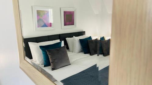 um reflexo de uma cama com almofadas azuis e brancas em Maberic Housing II em Hounslow