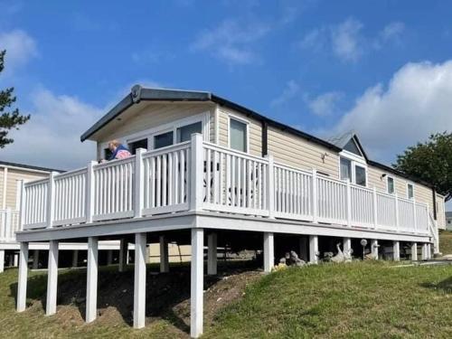 a person standing on a porch of a house at Sea Breeze Cabin in Poole