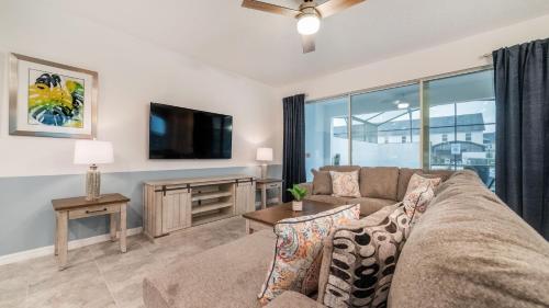 a living room with a couch and a tv at 8972 Amelia Downs in Orlando