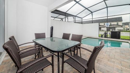 a dining room with a table and chairs and a swimming pool at 8972 Amelia Downs in Orlando