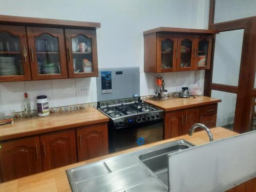 uma cozinha com armários de madeira e um forno com placa de fogão em Casa Grande em Iquitos