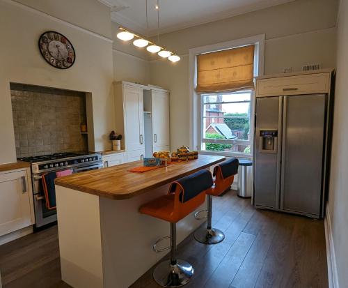 a kitchen with a wooden counter top and a refrigerator at Cotswold VIP Regency Lodge in Cheltenham