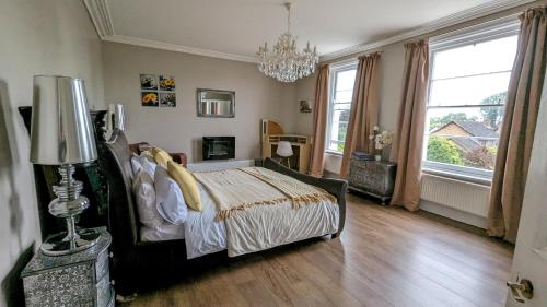 a bedroom with a bed and a chandelier at Cotswold VIP Regency Lodge in Cheltenham