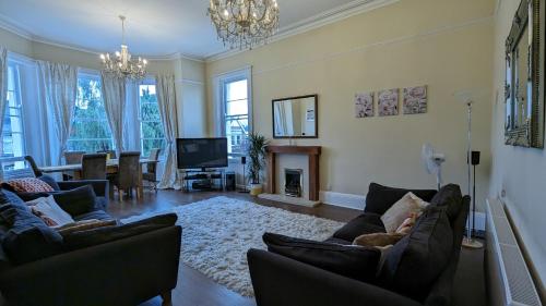 a living room with two couches and a fireplace at Cotswold VIP Regency Lodge in Cheltenham
