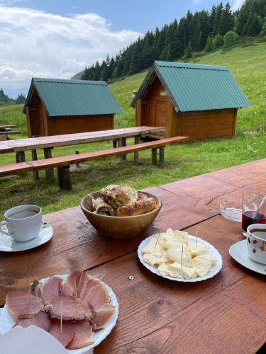 a wooden table with a bowl of food and chips at Eko Katun Damjanovic - Bjelasica in Mojkovac