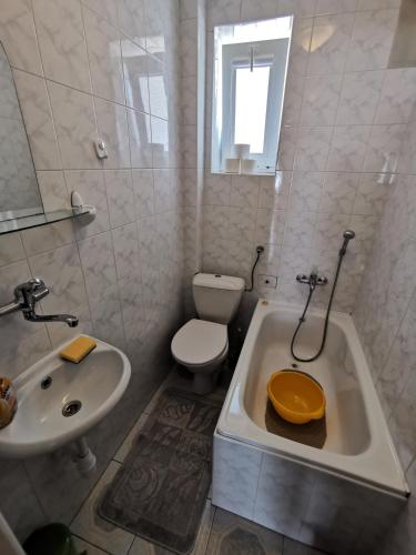 a bathroom with a sink and a toilet and a tub at Pokoje Gościnne KASZUB in Karwia
