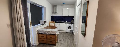 una pequeña cocina con lavadora y secadora. en White House Ensuite double bedroom en Warrington