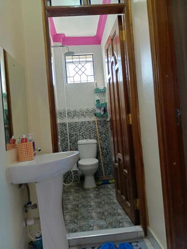 a small bathroom with a toilet and a sink at ROYAL APARTMENT MAKUPA in Mombasa