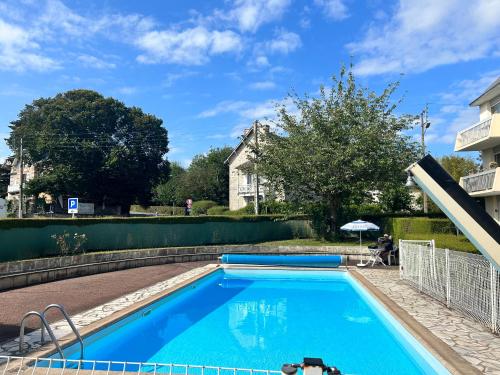 una piscina en un patio con una casa en Appartement terrasse privée grande plage à 100 m - Parking gratuit, en Saint-Cast-le-Guildo