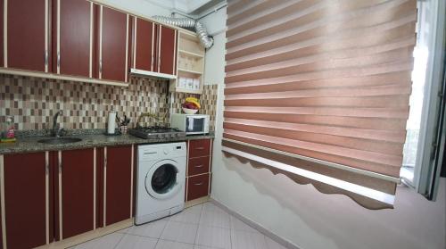 eine Küche mit roten Schränken und einer Waschmaschine in der Unterkunft Clover Flower House Only for Females ZEYTİNBURNU in Istanbul