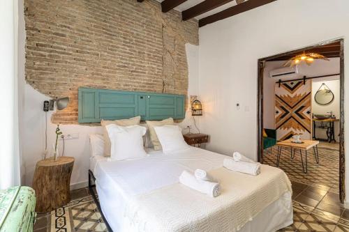 ein Schlafzimmer mit einem großen Bett und einer Ziegelwand in der Unterkunft Kala Ático - Apartamento Centro Jerez in Jerez de la Frontera