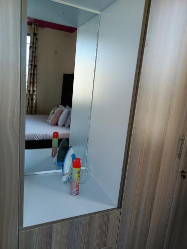 a mirror reflection of a bedroom with a bed in a room at ROYAL APARTMENT MAKUPA in Mombasa