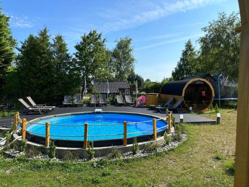 a swimming pool in a yard with a tent at Na Jeziornej Domki Wypoczynkowe in Żarnowska