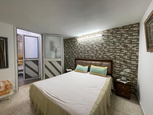 ein Schlafzimmer mit einem Bett und einer Ziegelwand in der Unterkunft Kelibia in Kelibia