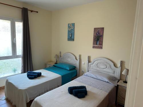 um quarto com 2 camas com almofadas azuis em Corralejo Happy em Corralejo