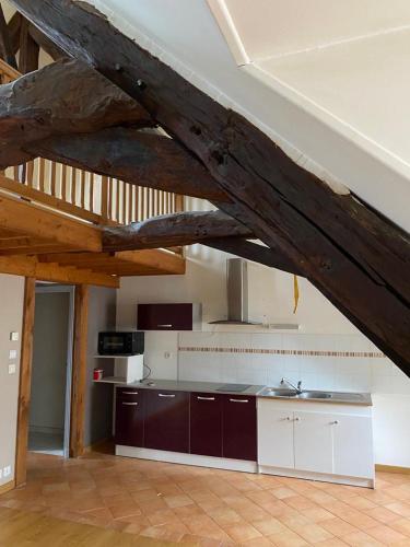 a kitchen with an attic with a wooden ceiling at Loft duplex de charme 8 p plein centre in Lisieux