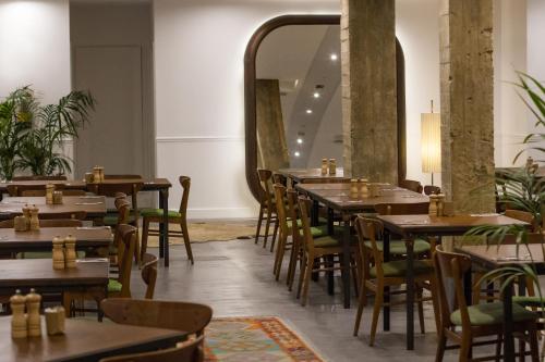 un restaurante con mesas, sillas y un espejo grande en 7 Islas Hotel, en Madrid