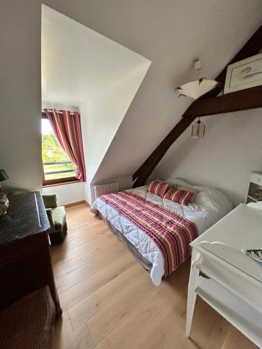 een slaapkamer met een bed en een raam bij Le Pré des Fées in Salbris