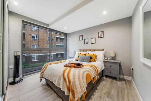 a bedroom with a bed and a large window at Modern 1 Bed Apt by Old Street / Shoreditch in London