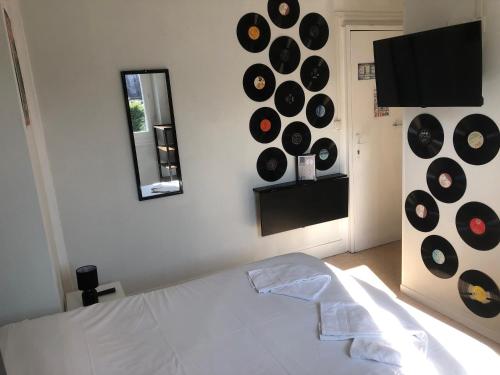 - une chambre dotée d'un lit avec des disques sur le mur dans l'établissement L'Ambroisie, à Pont-d'Ouilly