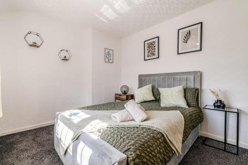 a bedroom with a large bed with two pillows at 3-Bed House Near Lakeside Mall, Onsite Parking in Grays Thurrock