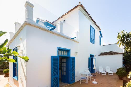 a white house with blue doors and a patio at La Hacienda Grande in Puerto de la Cruz