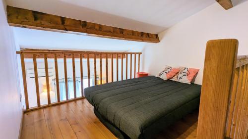 a bedroom with a bed and a large window at Maison de village avec garage in Aigues-Mortes