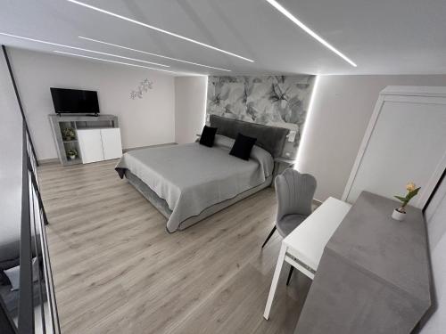 a bedroom with a bed and a table and a television at Affittacamere La Magnolia in Bacoli