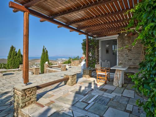 une terrasse avec une pergola en bois et un banc dans l'établissement Sea View Exclusive Studios - Tinos, à Agios Ioannis