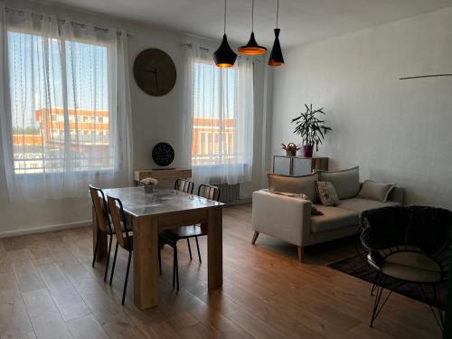 un salon avec une table et un canapé dans l'établissement Douai 2: joli appartement face à la gare, à Douai