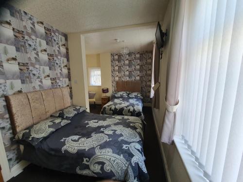 a bedroom with two beds and a window at Windsor House Hotel in Blackpool