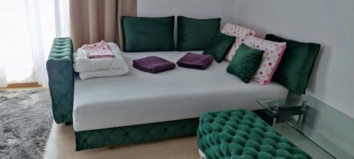 una cama verde y blanca con almohadas. en Studio P&N Raj, en Vrnjačka Banja